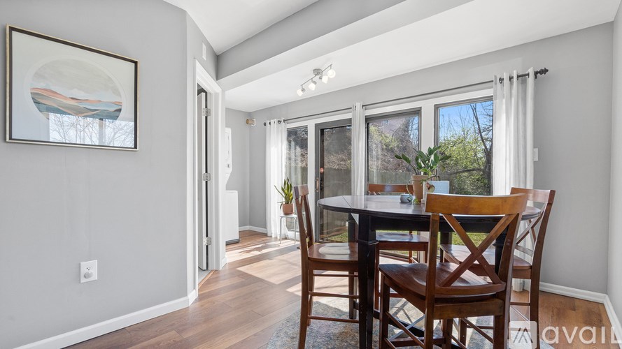 A dining room with a table and chairs.