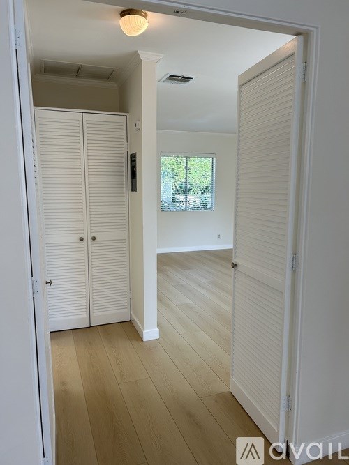 A kitchen with white cabinets and a brown countertop.