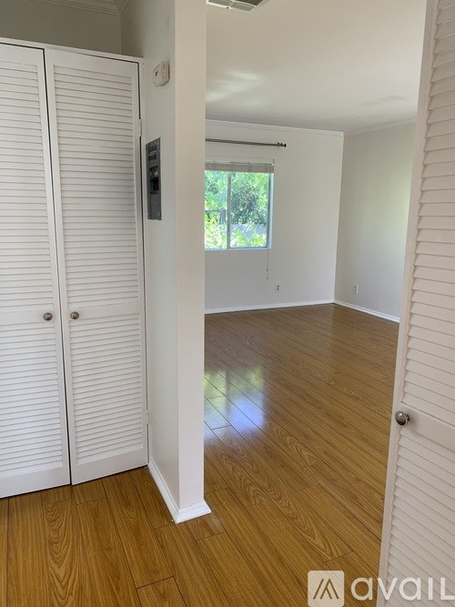 A room with wooden flooring and white walls.
