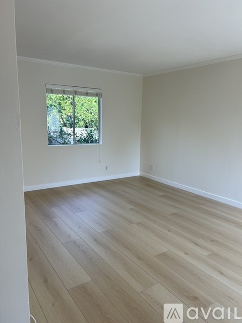 A room with wooden flooring and white walls.