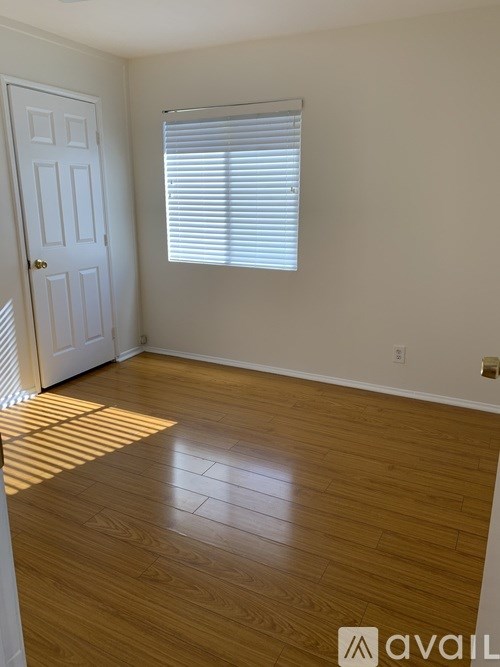 A room with wooden flooring and a white door.