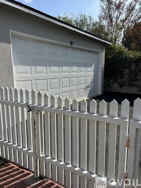 A white garage door is closed and locked.