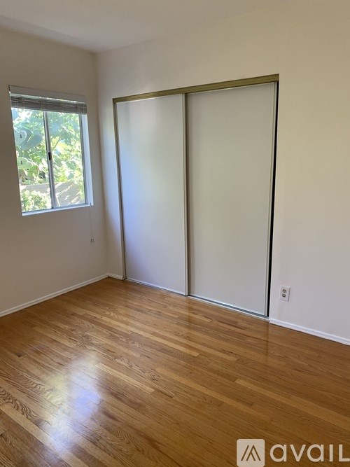 A room with a sliding door and wooden flooring.