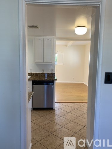 A kitchen with white cabinets and a granite countertop.