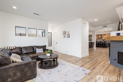 A living room with a brown leather couch and a coffee table.