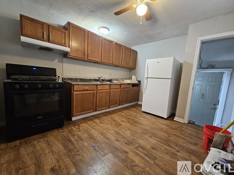 A kitchen with wooden cabinets and a black stove top oven.