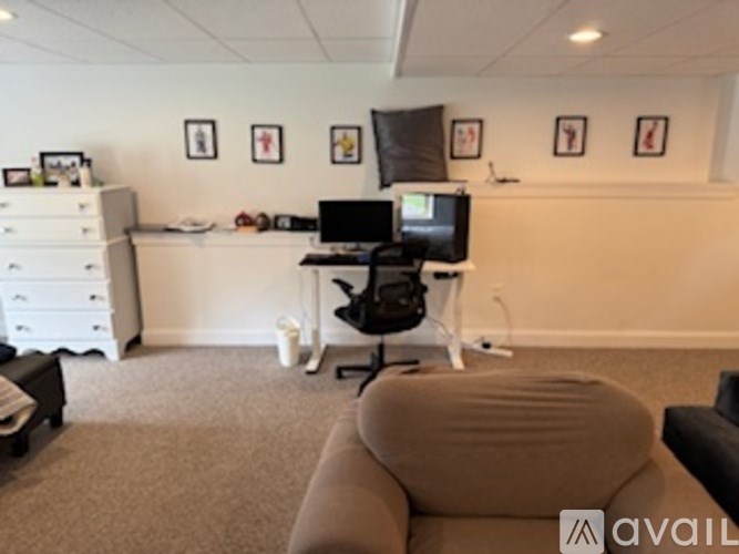 A room with a couch, a desk, and a computer.