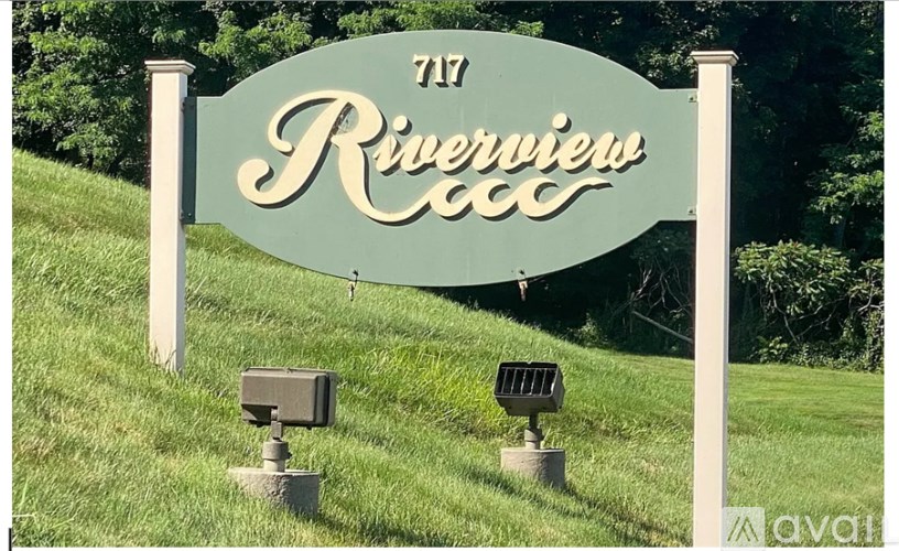 A sign for Riverview Golf Club with two small boxes attached to the bottom.