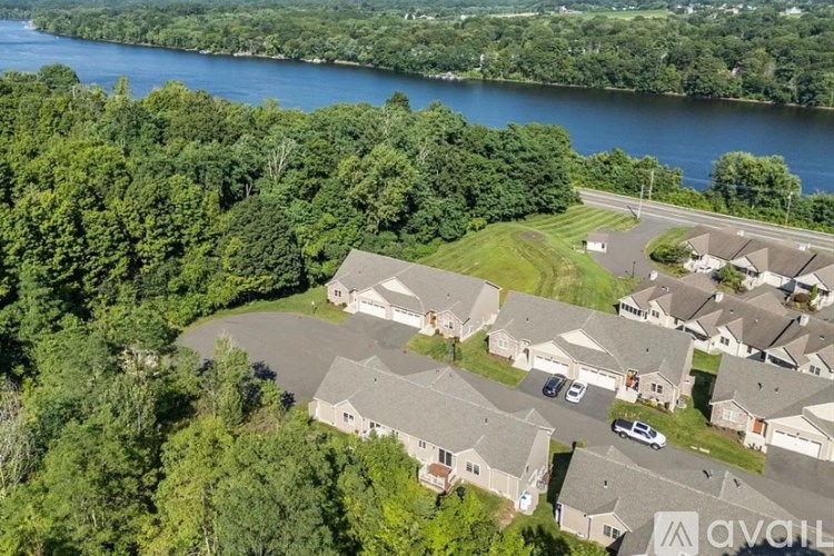 A bird's eye view of a residential area with houses and a river in the background.