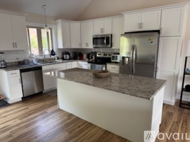 A kitchen with a granite counter top and stainless steel appliances.