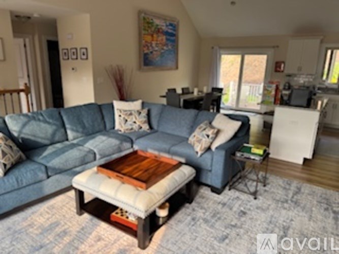 A blue couch with a wooden coffee table in front of it.