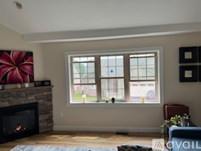 A living room with a fireplace and a large window.
