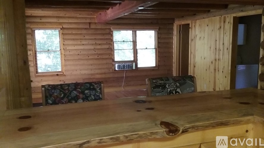 A wooden room with a window and a couch.