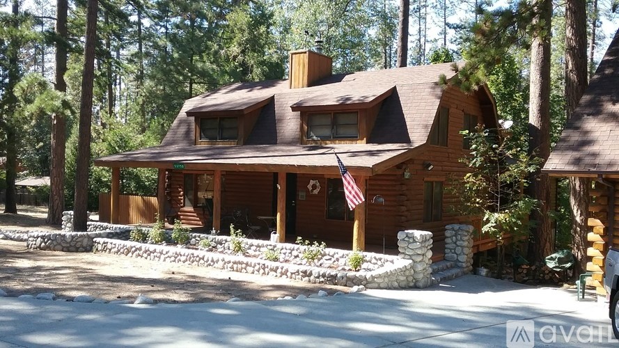 A wooden house with a flag on the front porch.