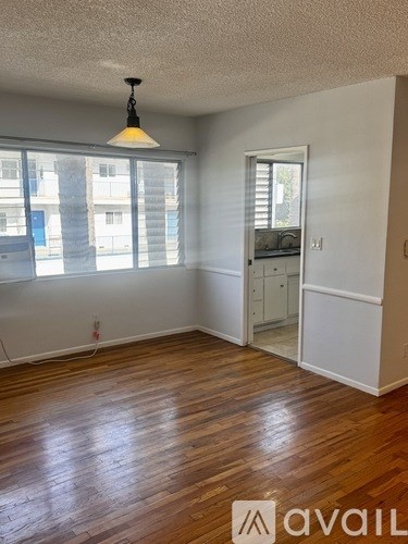 A room with wooden floors and a window with blinds.