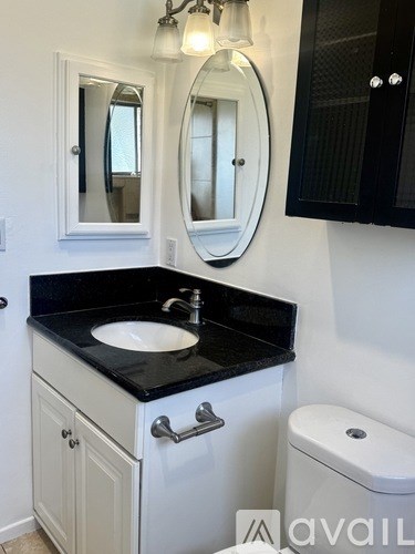 A bathroom with a sink, mirror, and toilet.
