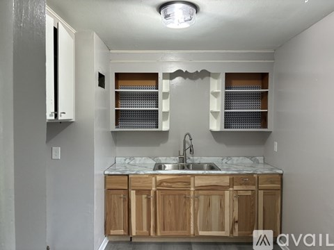 A kitchen with wooden cabinets and a marble countertop.