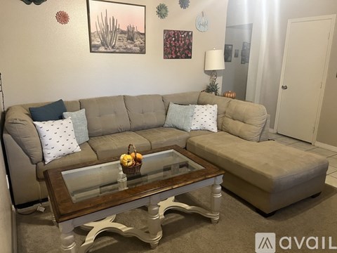 A living room with a grey couch and a coffee table.