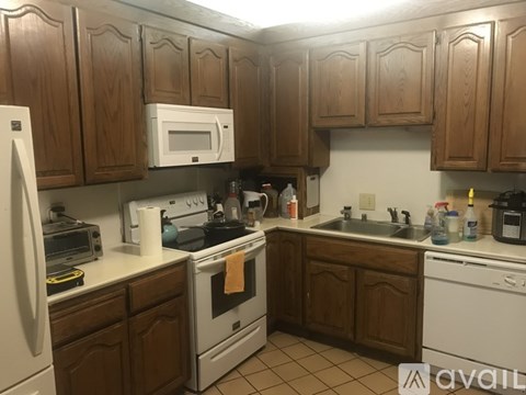 A kitchen with wooden cabinets and white appliances.