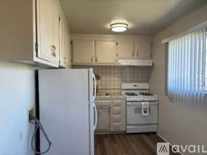 A kitchen with white appliances and cabinets.