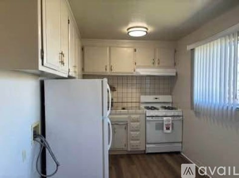 A kitchen with white appliances and cabinets.