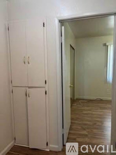 A room with a white door and a wooden floor.