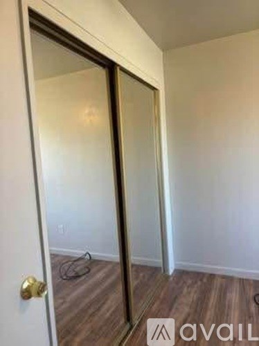 A room with a white door and a wooden floor.