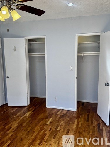 A room with a ceiling fan and wooden floors.