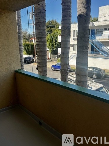 A balcony with a view of a street with cars and buildings.