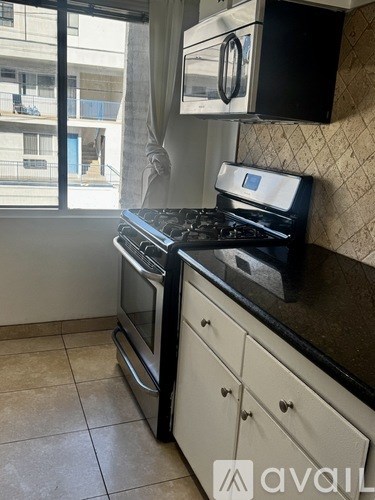 A kitchen with a black countertop and white cabinets.