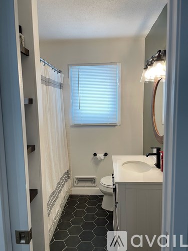 A bathroom with a toilet, sink, and shower.