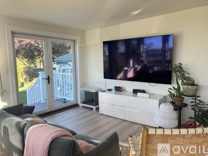 A living room with a flat screen TV mounted on the wall.