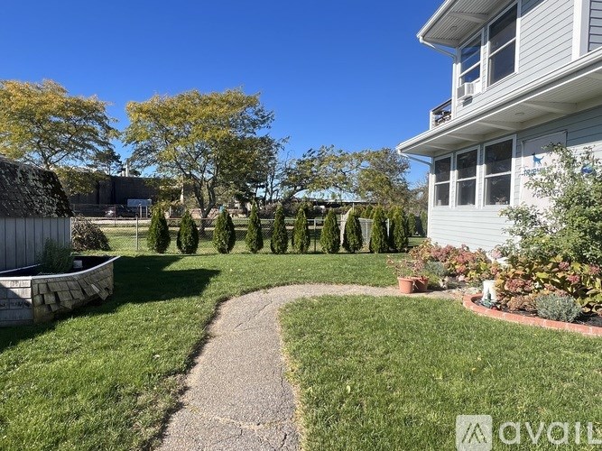 A well-maintained lawn with a gravel path leading to a house.