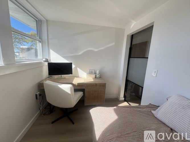 A room with a desk and a chair with a computer on it.