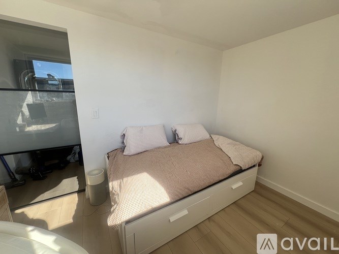 A bedroom with a bed, pillows, and a window.