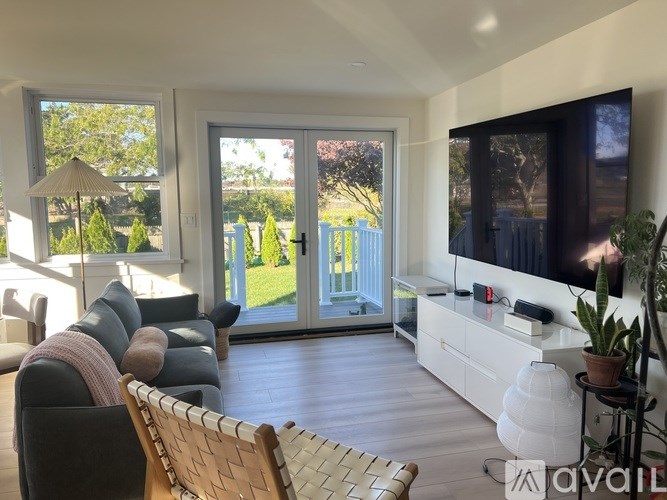 A living room with a large flat screen TV mounted on the wall.