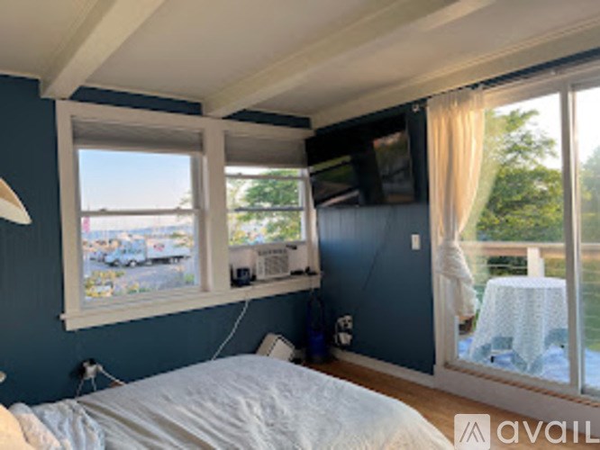 A bedroom with a bed, a window, and a television.