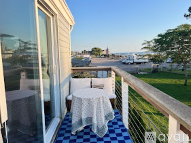 A balcony with a table and chairs overlooking a parking lot.