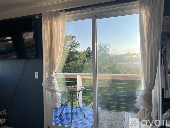 A balcony with a table and chairs overlooking a body of water.
