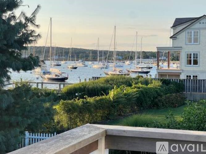 A marina with boats and a house with a balcony overlooking it.