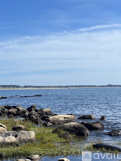 A rocky shoreline with water and sky in the background.
