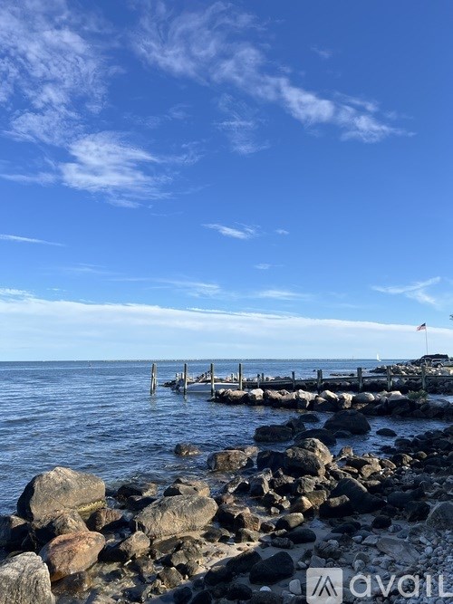 A rocky shoreline with a wooden pier extending into the water.