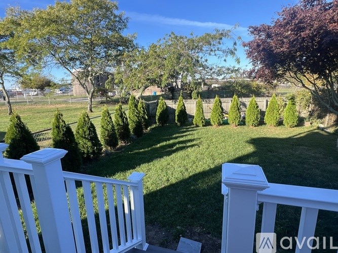 A white fence borders a well-kept lawn.