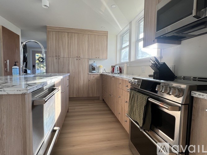 A kitchen with wooden cabinets and a marble countertop.