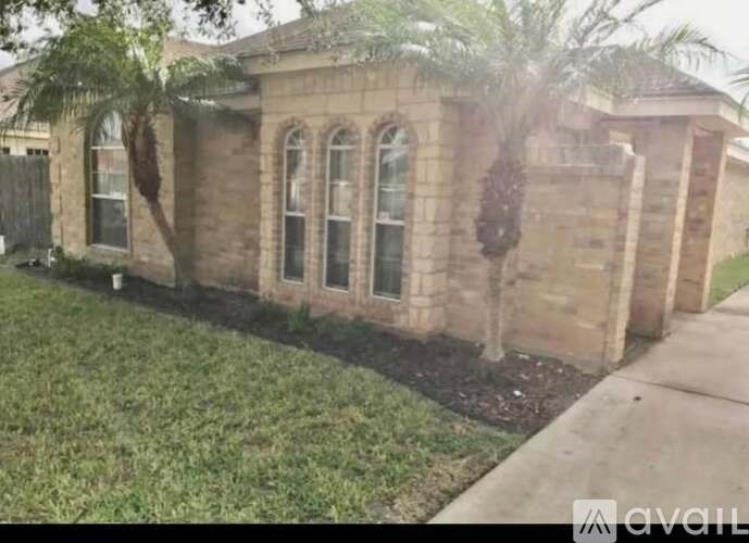 A house with a brown brick exterior and a green lawn.