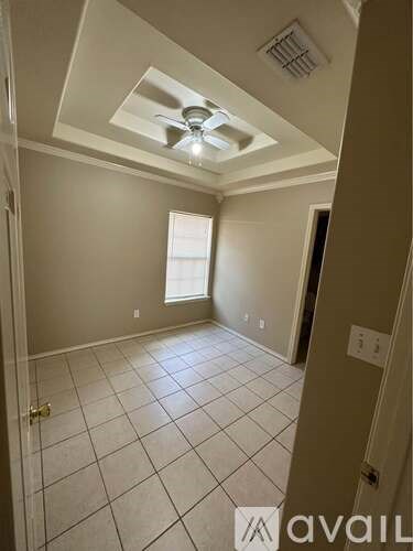 A room with a ceiling fan and tile flooring.