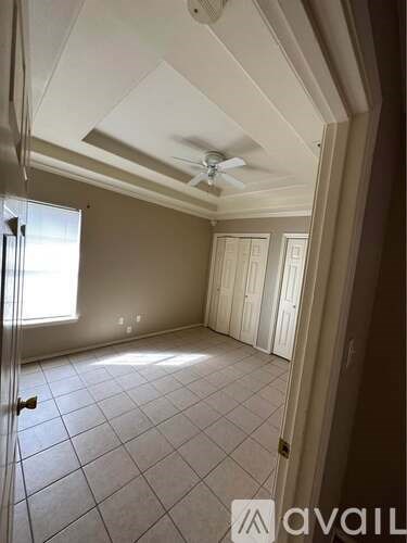 A room with a ceiling fan and tile flooring.