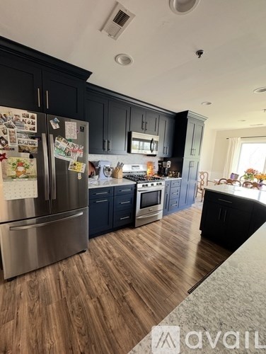 A kitchen with a refrigerator covered in magnets.