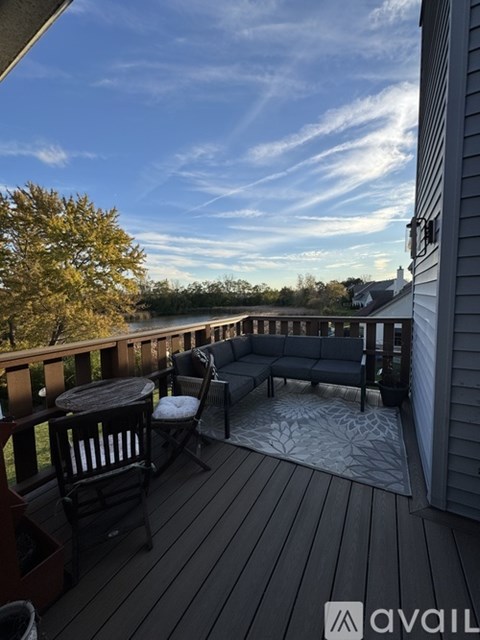 A wooden deck with a table and chairs overlooking a body of water.
