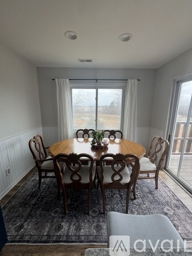 A dining room with a round table and chairs.